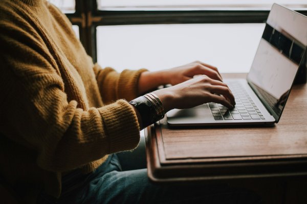 Person writing on a laptop